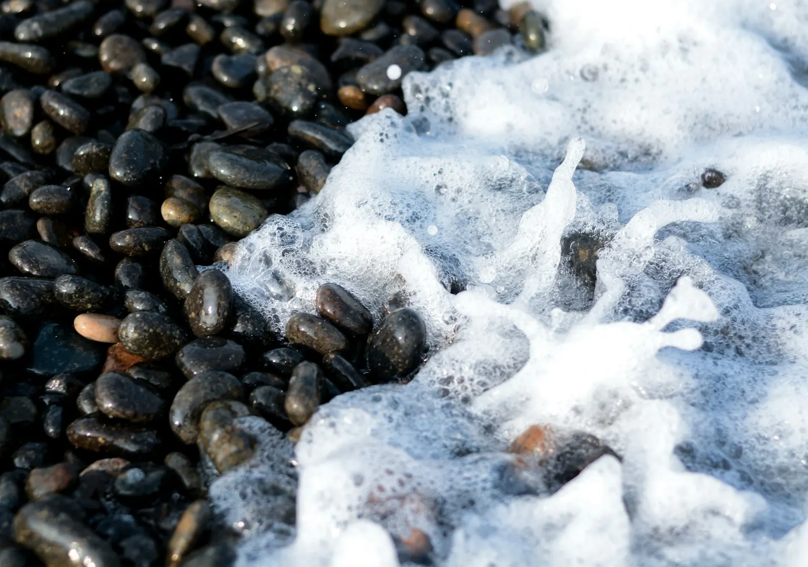Pacific surf washing over dark pebbles on a British Columbia beach